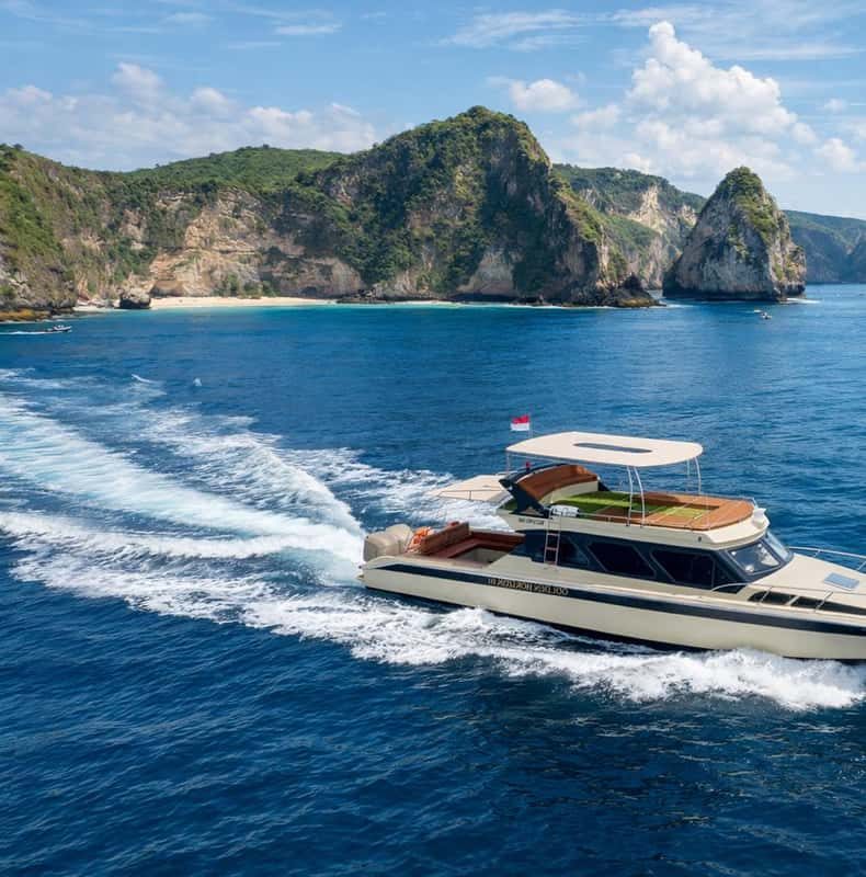 A private catamaran anchored off the Bali coast with guests aboard